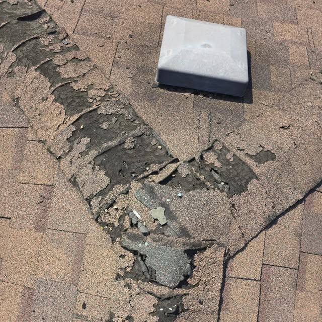 Worn, broken shingles around a roof vent